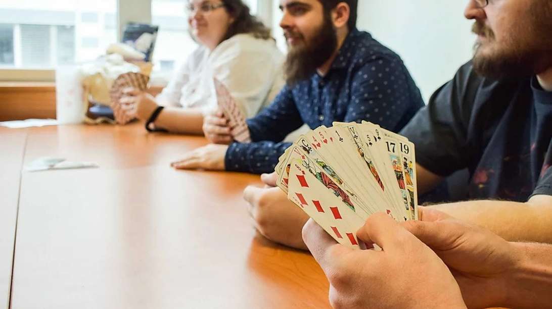 Collaborateurs qui jouent aux cartes à 12h00